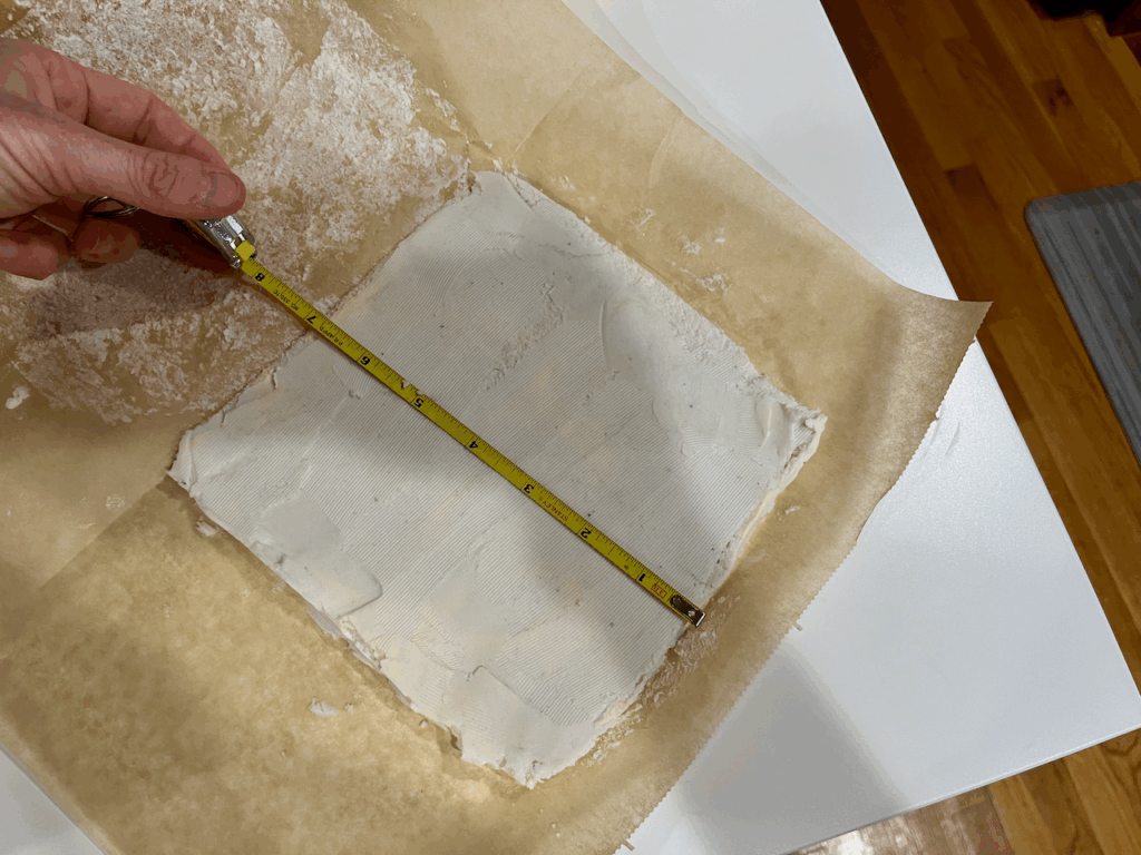 A 7 inch by 7 inch square of vegan butter on parchment paper
